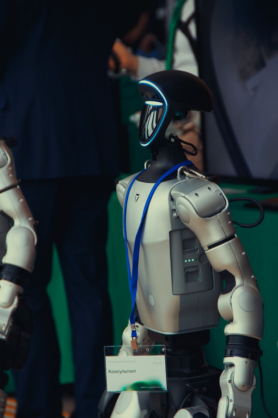 Humanoid robot with blue visor at an indoor event.